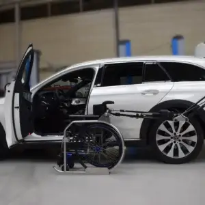 Robot R11 guardando silla de ruedas desde la plaza del conductor con su brazo alargado