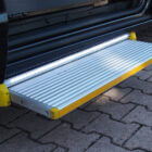 Escalón eléctrico TRAN-STE en lateral de vehículo adaptado